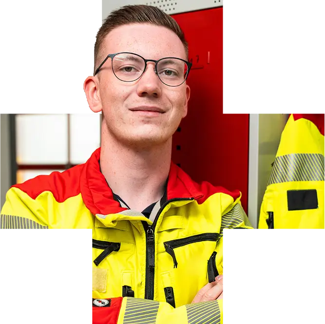 Sanitäter in gelb-roter Einsatzkleidung steht selbstbewusst vor einem roten Spind im Dienstbereich.