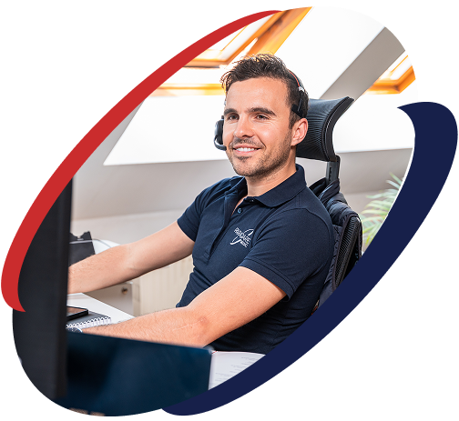 Mitarbeiter von ParaQare mit Headset arbeitet am Schreibtisch und betreut Kunden telefonisch.