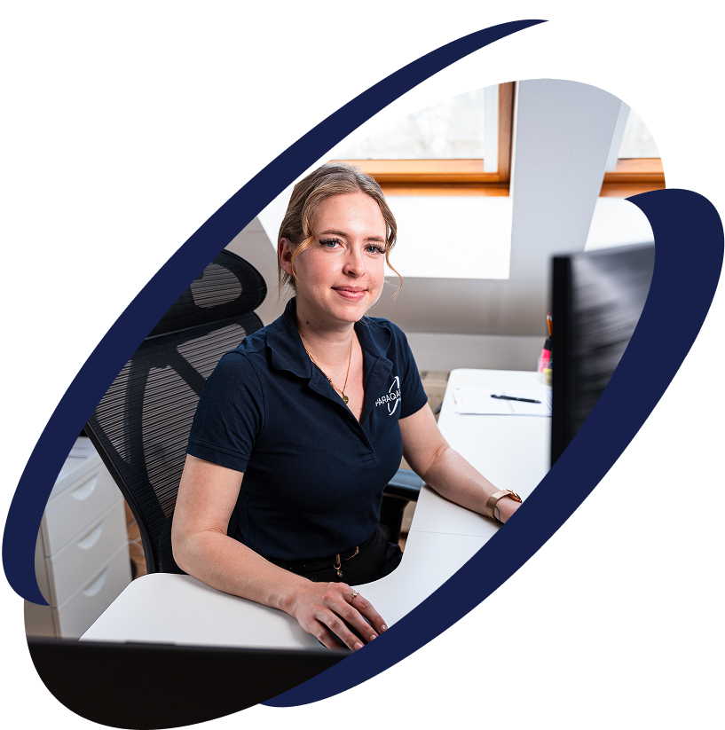 Mitarbeiterin von ParaQare sitzt an einem Schreibtisch und arbeitet konzentriert am Computer.