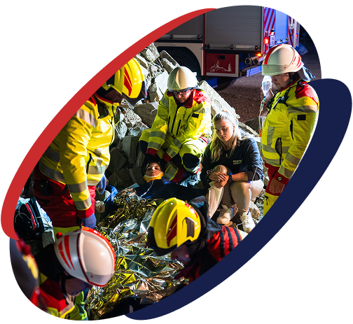 Mehrere Sanitäter versorgen eine verletzte Person bei einem nächtlichen Einsatz auf einer Baustelle.